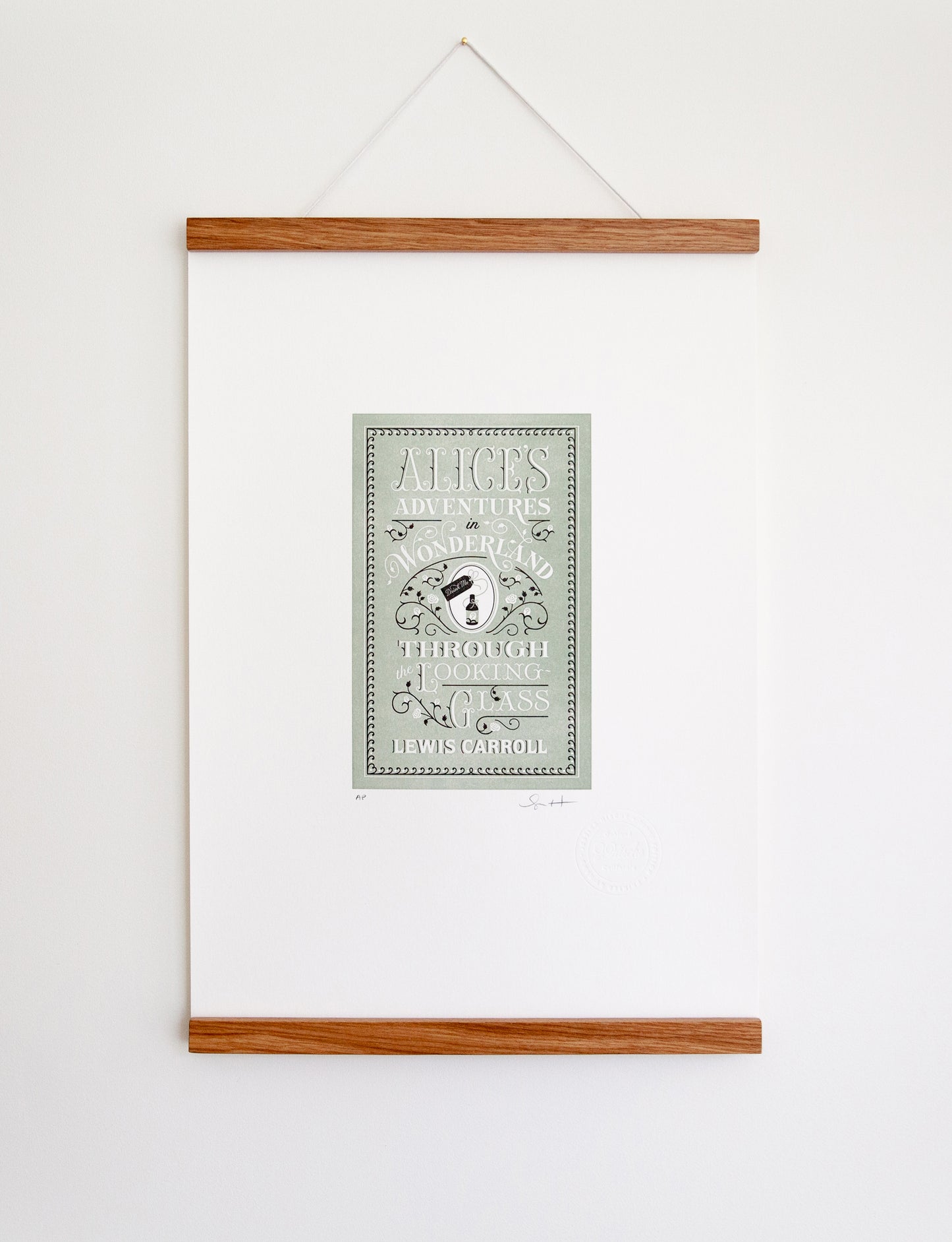Framed 2-color letterpress print in green and black. Printed artwork is an illustrated book cover of Alice's Adventures in Wonderland including custom hand-lettering.