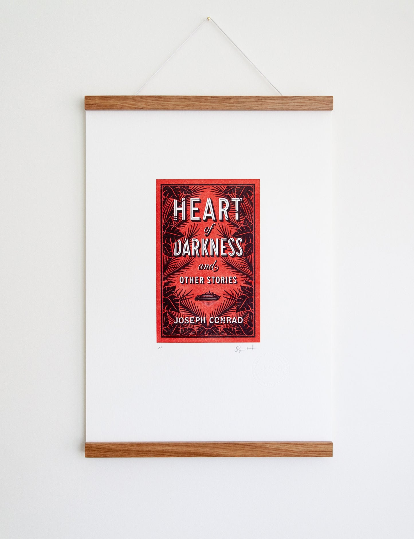 Framed 2-color letterpress print in red and black. Printed artwork is an illustrated book cover of Heart of Darkness including custom hand lettering.