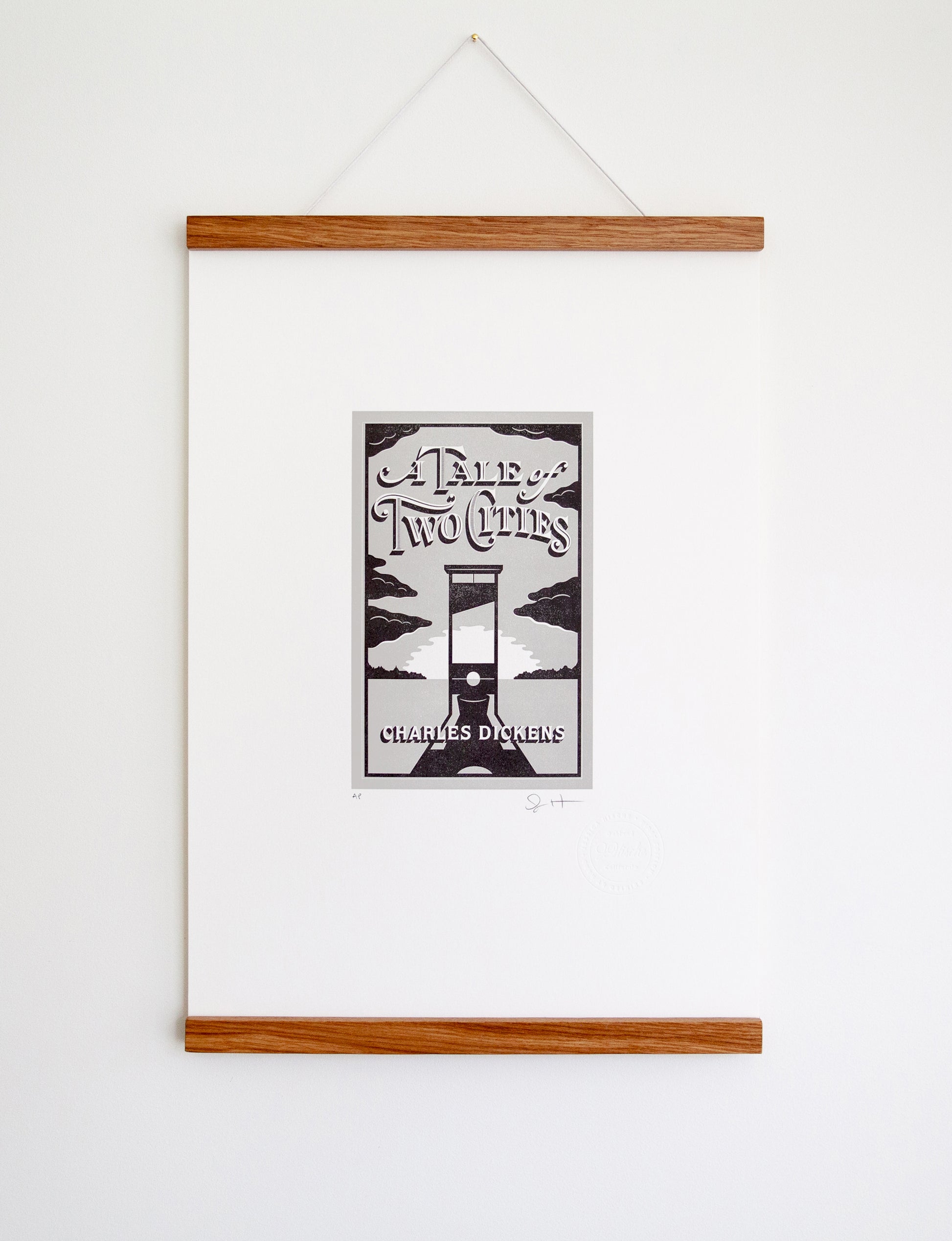 Framed 2-color letterpress print in gray and black. Printed artwork is an illustrated book cover of A Tale of Two Cities including custom hand lettering.