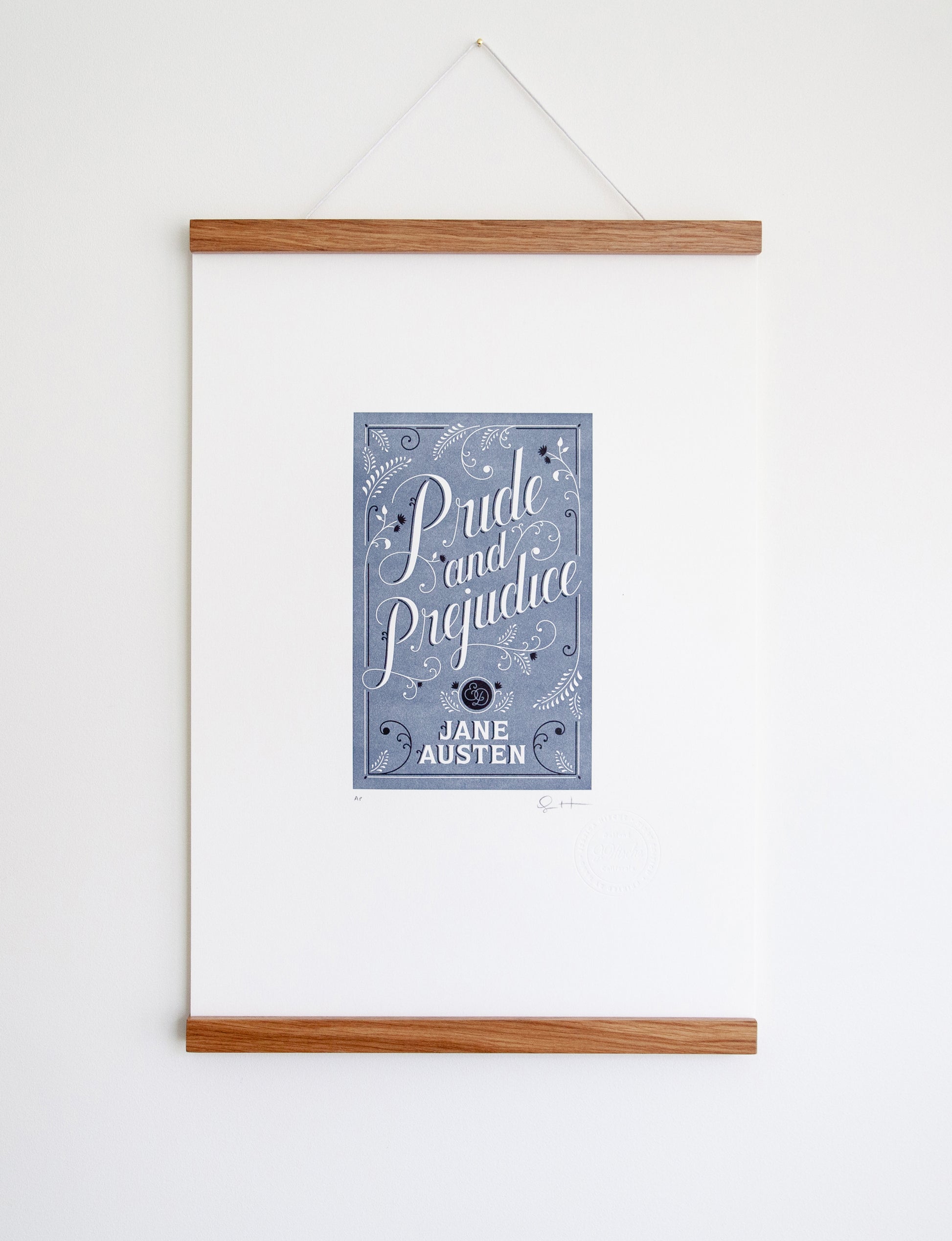 Framed 2-color letterpress print in blue and black. Printed artwork is an illustrated book cover of Pride and Prejudice including custom hand lettering.