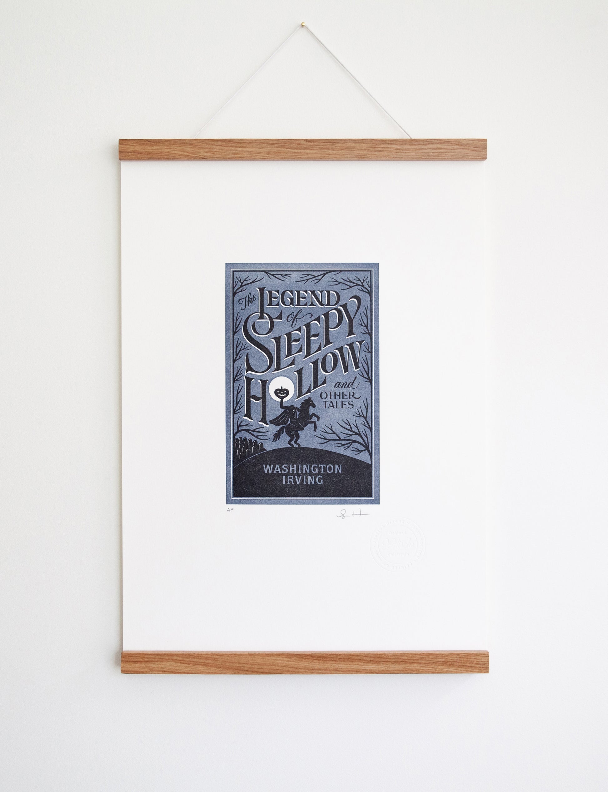 Framed 2-color letterpress print in blue and black. Printed artwork is an illustrated book cover of The Legend of Sleepy Hollow including custom hand lettering.