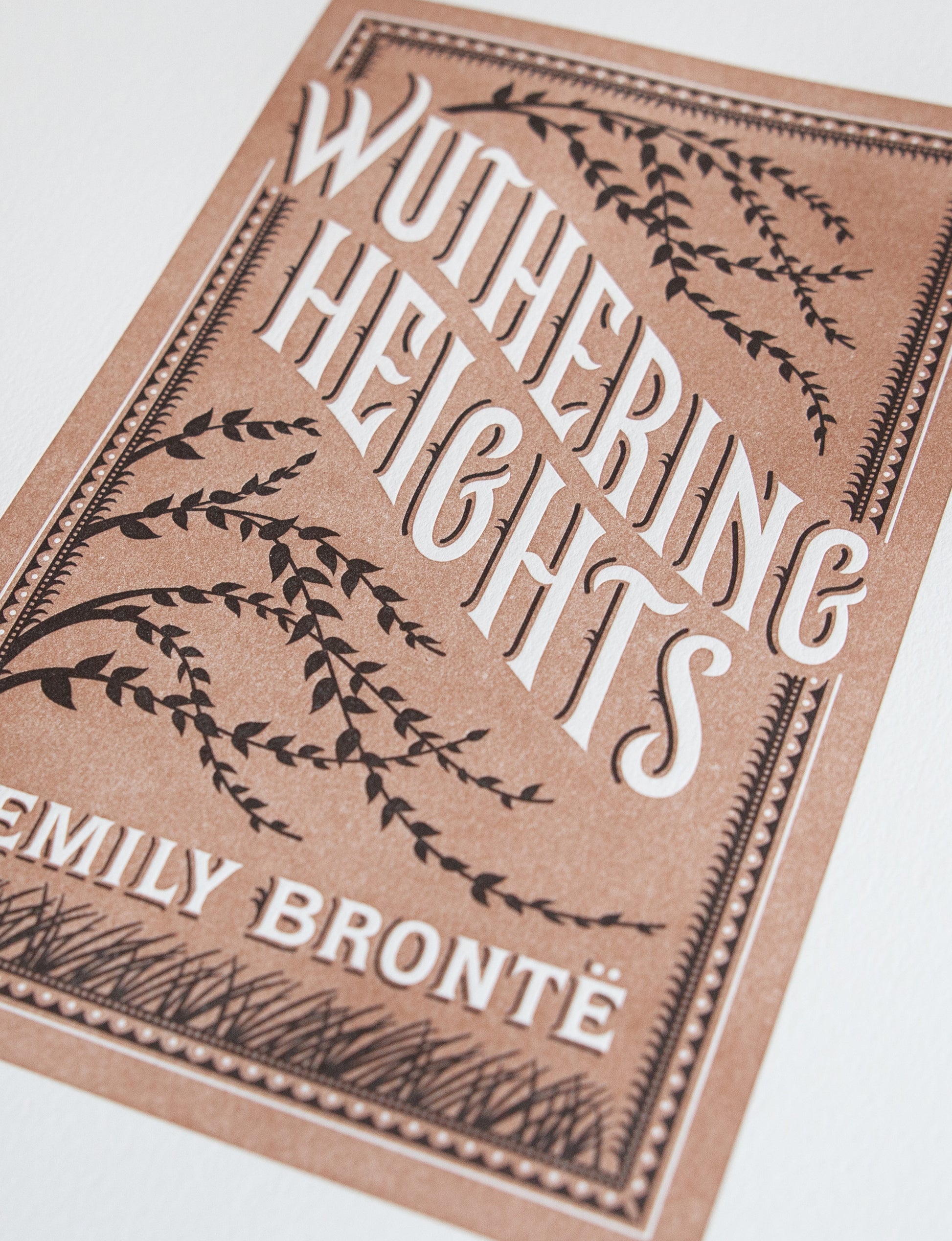 Close-up of a 2-color letterpress print in brown and black. Printed artwork is an illustrated book cover of Wuthering Heights including custom hand lettering.